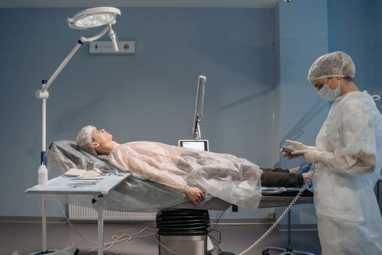 Surgical setup in a hospital room with medical staff and patient in sterile clothing.