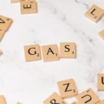 Scrabble tiles on marble spelling 'Gas', perfect for energy concept visuals.