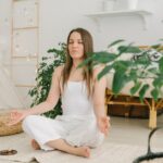 Peaceful meditation scene with a woman practicing mindfulness in a cozy, plant-filled indoor space.