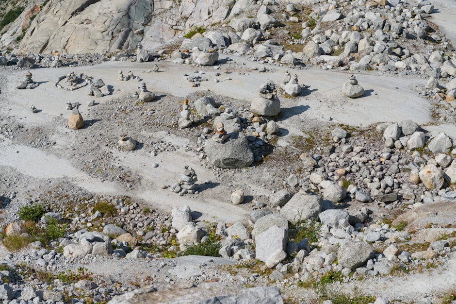 Stone cairns on a rugged, rocky landscape in the Swiss outdoors under daylight.