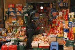 A vibrant snack shop with diverse packaged snacks and candies in a bustling market.