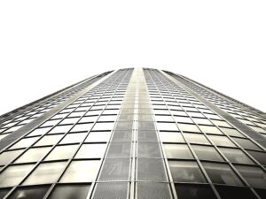 Low angle shot of a modern skyscraper with a glass facade and steel structure.